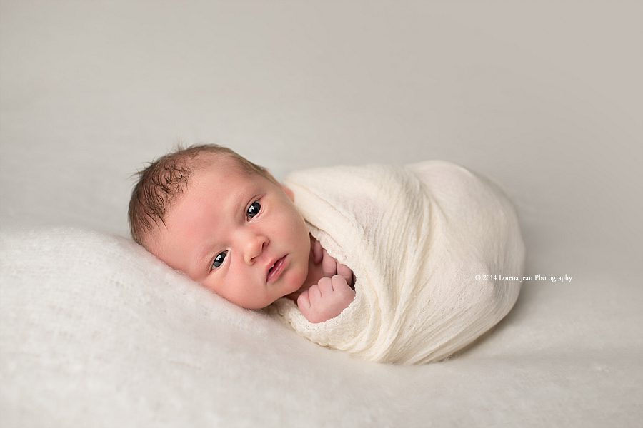 wide awake newborn in white wrap