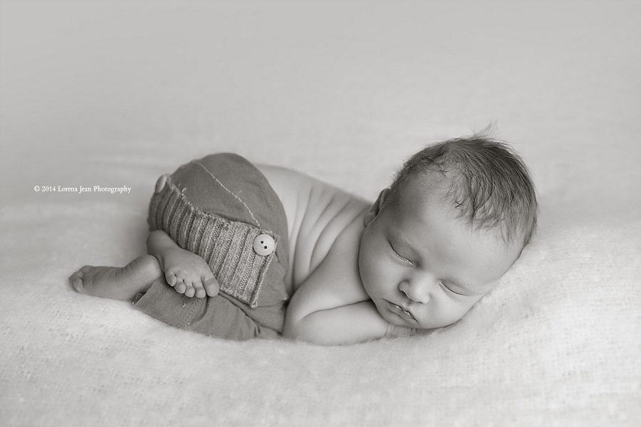 newborn posed on white backdrop black and white